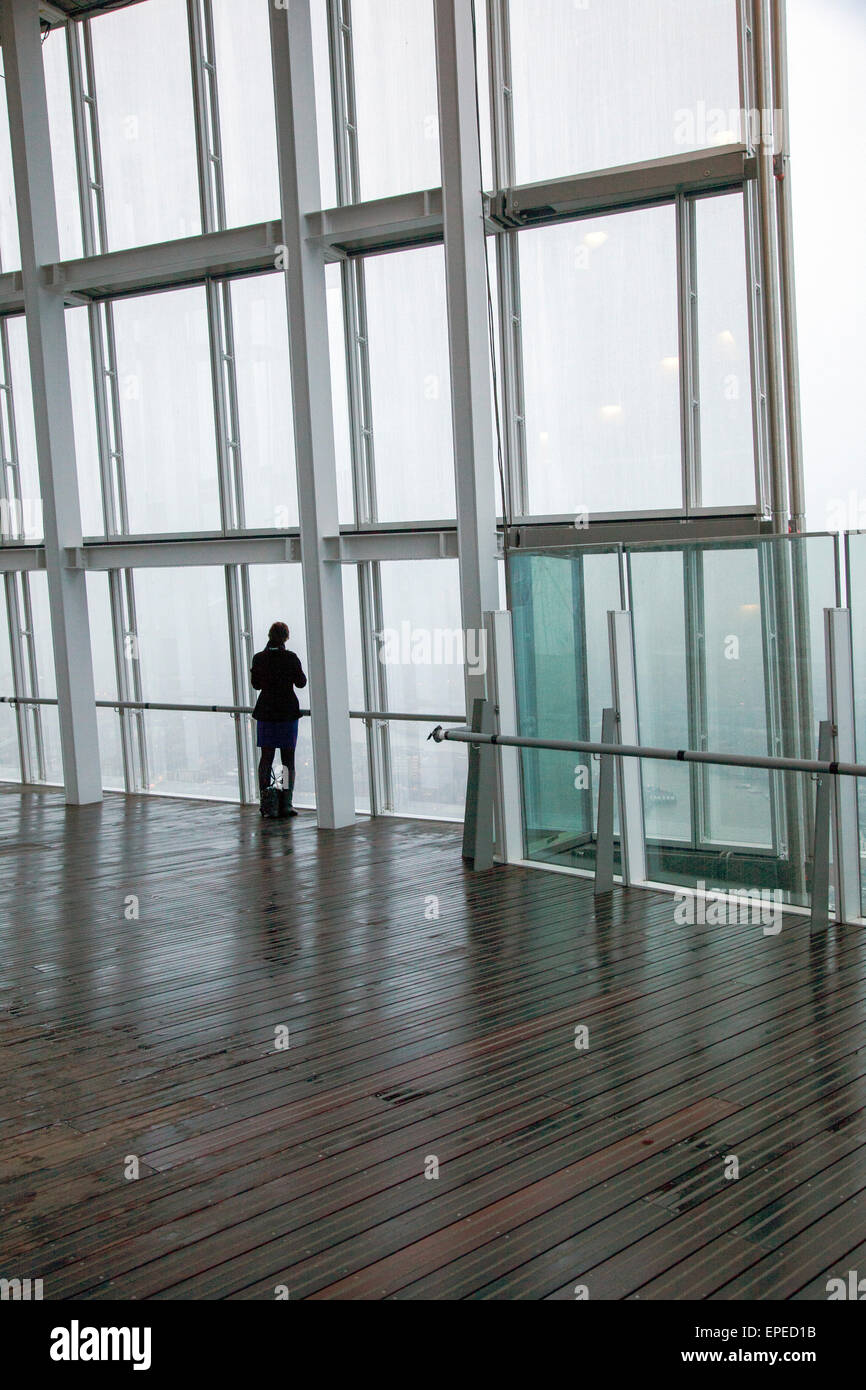 La figura guardare le nuvole che si muovono in su Londra. La Shard, Londra, Regno Unito. Architetto: Renzo Piano Building Workshop, 2 Foto Stock La figura guardare le nuvole che si muovono in su Londra. La Shard, Londra, Regno Unito. Architetto: Renzo Piano Building Workshop, 2 Foto Stock