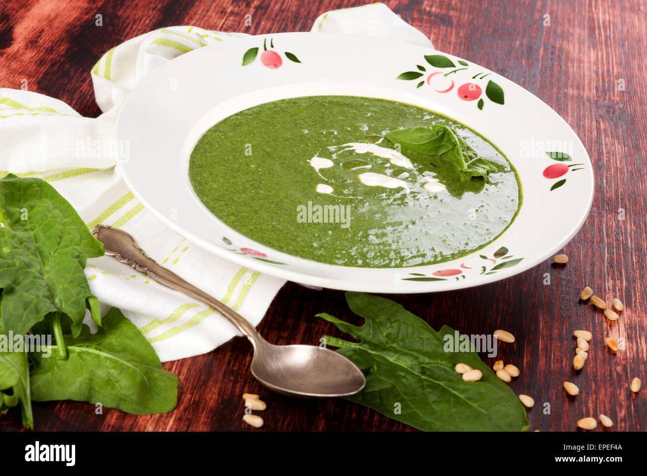 Freschi e deliziosi zuppa di spinaci freschi con foglie di spinaci e pane su sfondo di legno, vista dall'alto. Zuppa di culinaria mangiare. Foto Stock