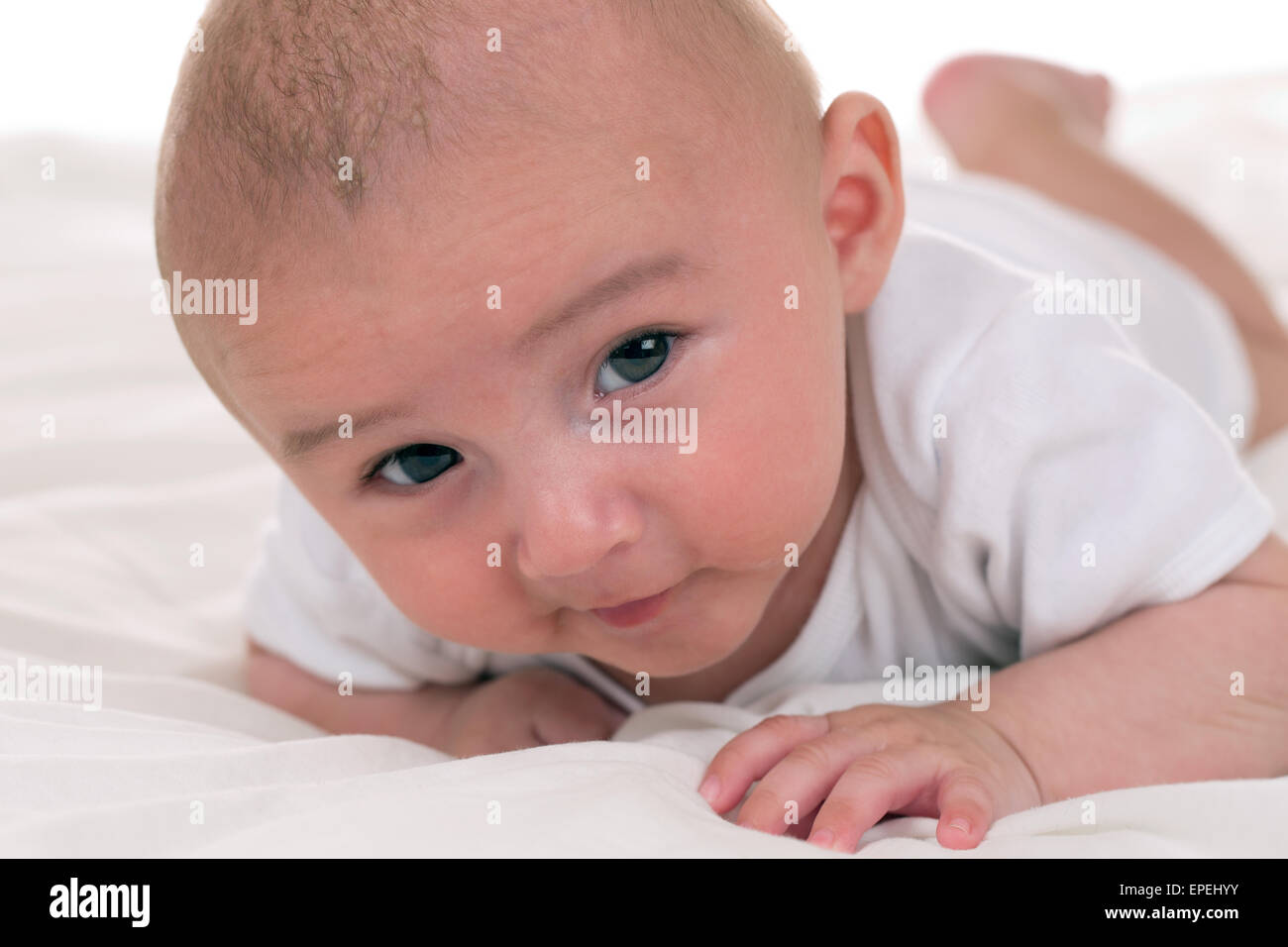 Kleines Baby krabbelt Bett im Foto Stock