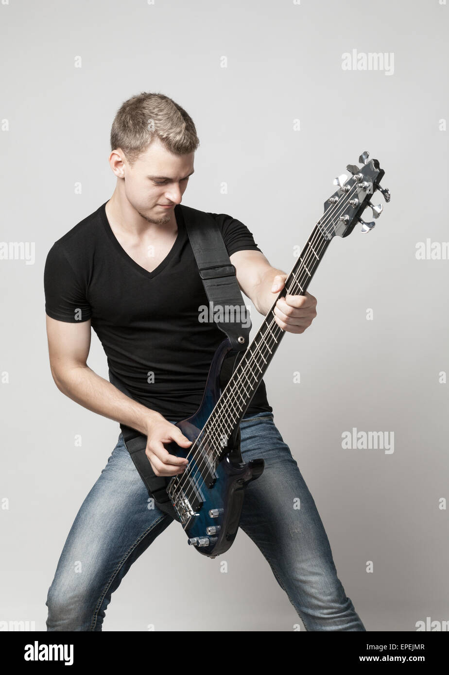 Musicista maschio giocando a sei-string bass guitar Foto Stock