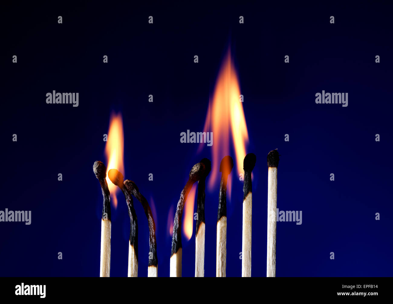 Ripresa macro di una fiammante matchstick su blu Foto Stock