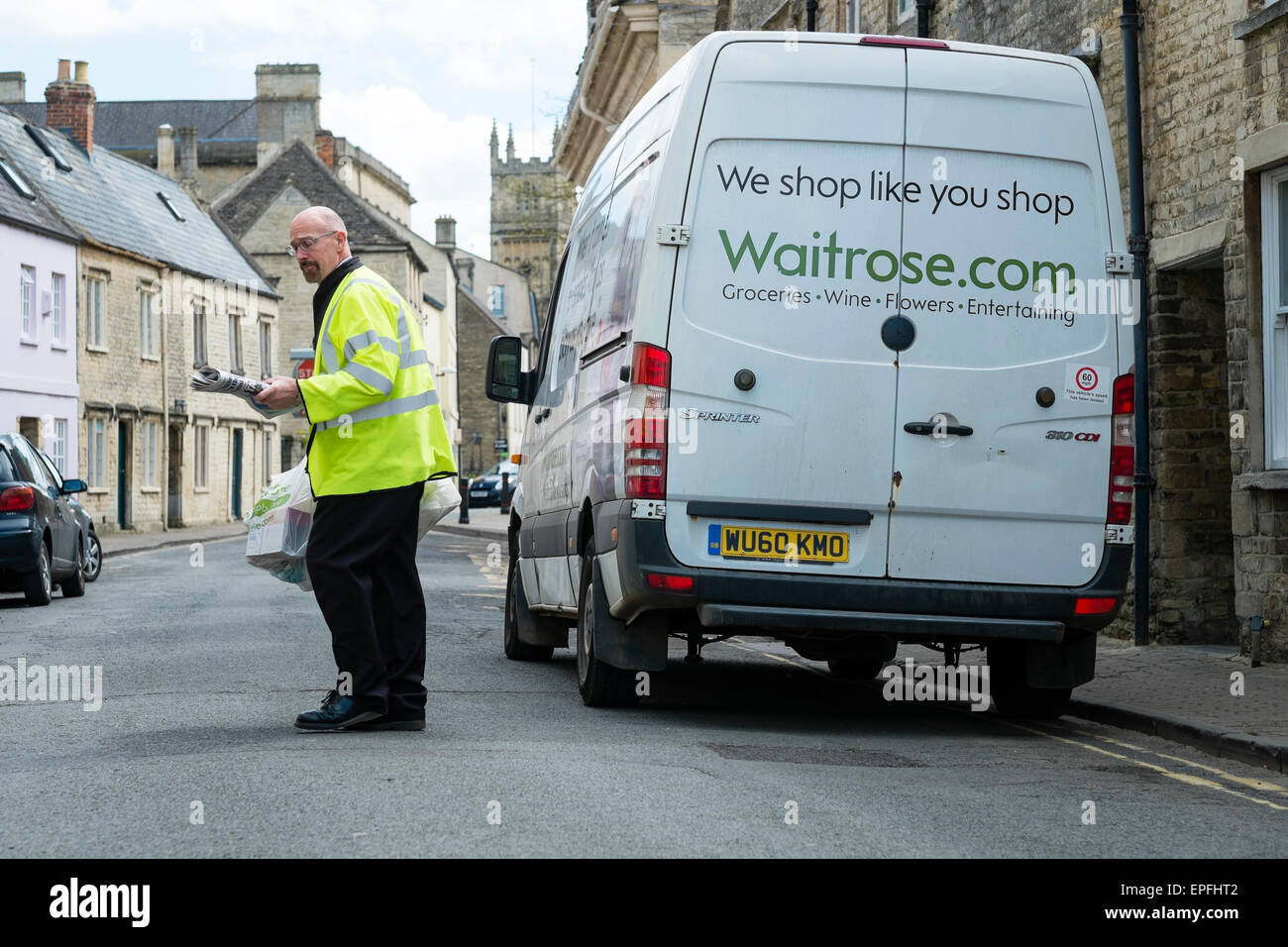 Un Waitrose (Waitrose.com) home delivery lavoratore portando un carrello per un cliente a Cirencester, Gloucestershire, England Regno Unito Foto Stock