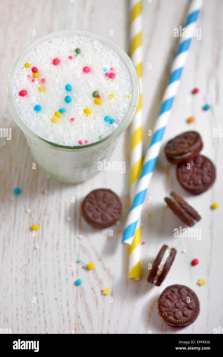 Un bicchiere di latte e biscotti e Cannucce di carta Foto Stock