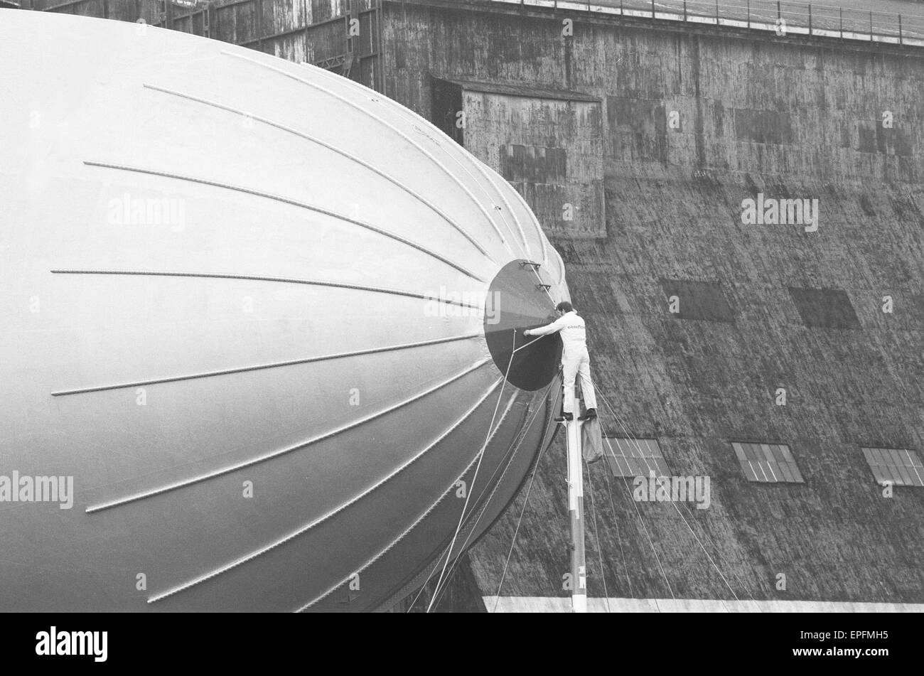 Uno del personale di terra si prepara a staccare il dirigibile Goodyear Europa dal suo montante di ormeggio al di fuori il gigante R101 capannoni a RAF Cardington formerly Royal dirigibile funziona, Bedfordshire. 8 Marzo 1972 Foto Stock