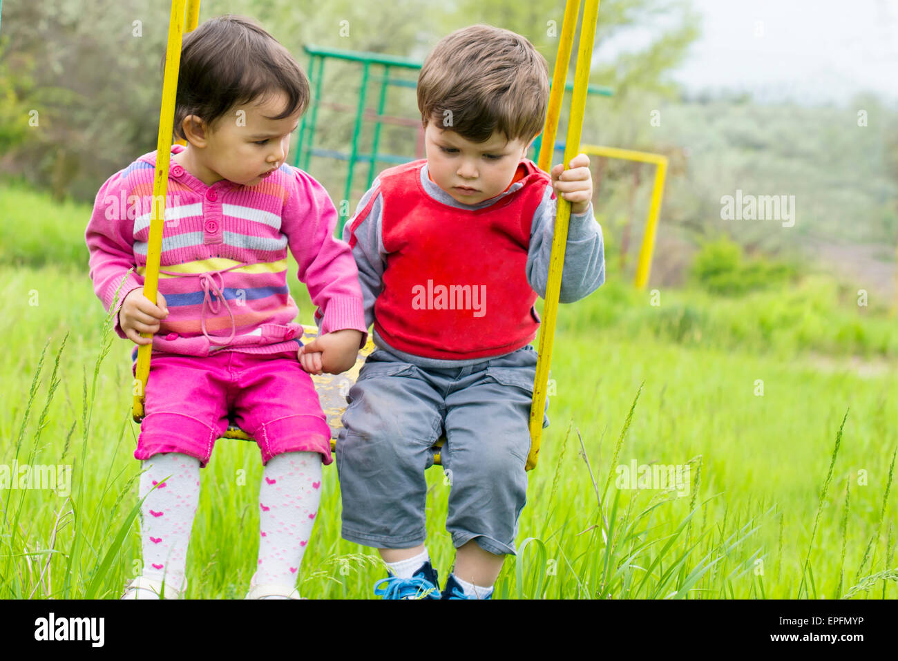 Due bambini che si divertono sull uno swing sul giorno di estate Foto stock  - Alamy