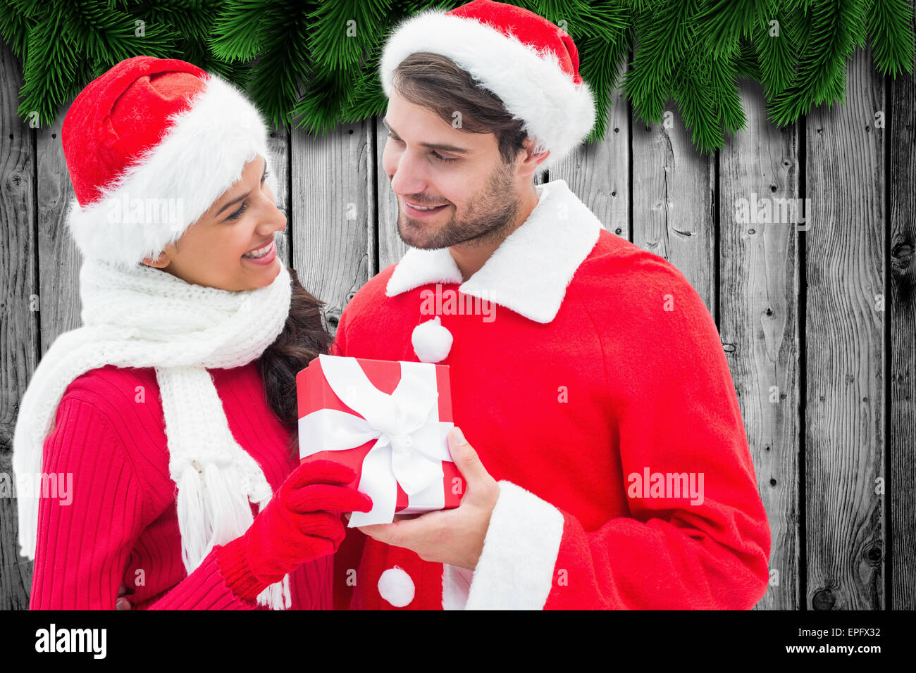 Immagine composita di festosa coppia giovane azienda dono Foto Stock