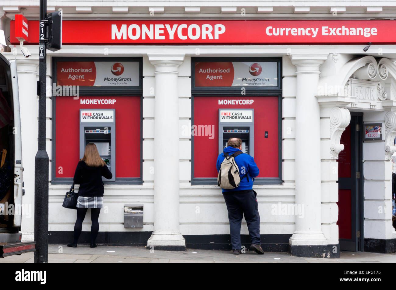Persone prelevare denaro dal bancomat nella parete di un Moneycorp Bank di Londra. Foto Stock