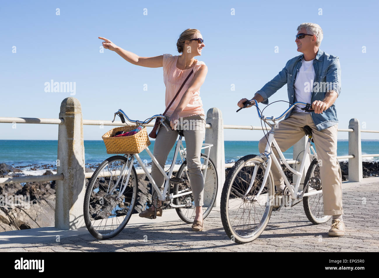 Felice coppia casual per andare per un giro in bici sul molo Foto Stock