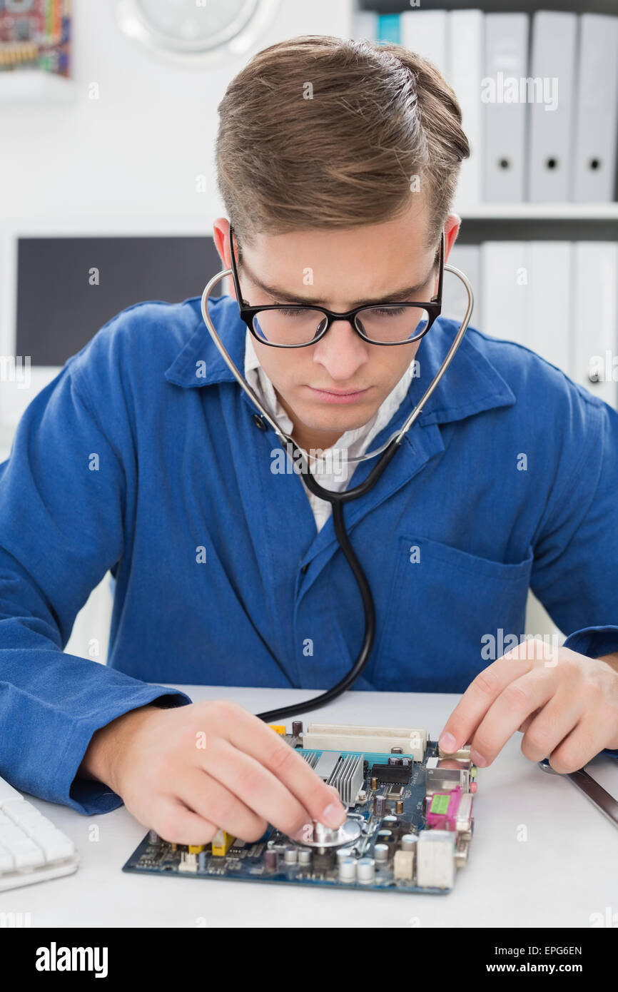 Ascolto tecnico alla CPU con uno stetoscopio Foto Stock