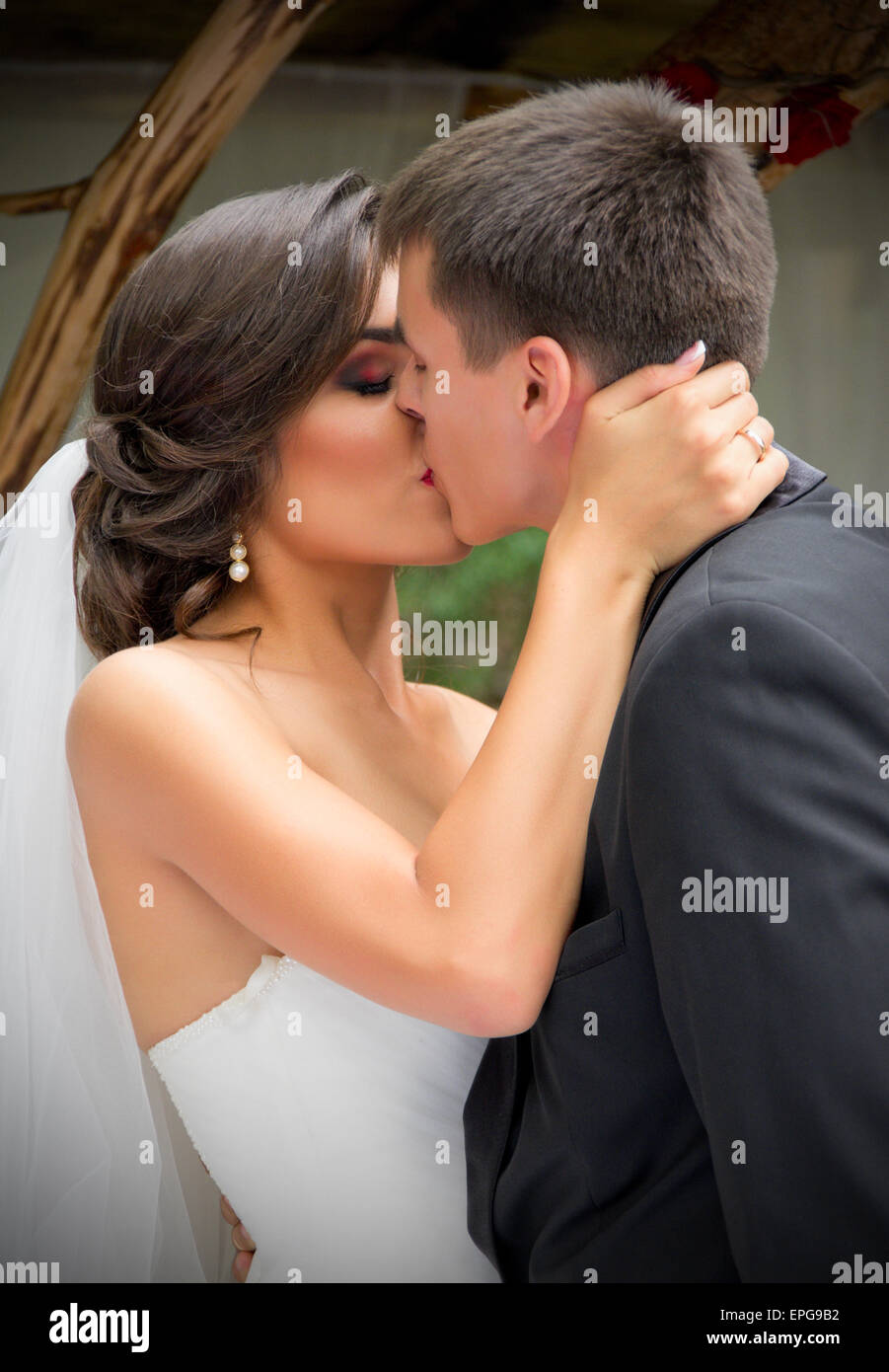 I giovani sposi novelli baciare e giorno di estate Foto Stock