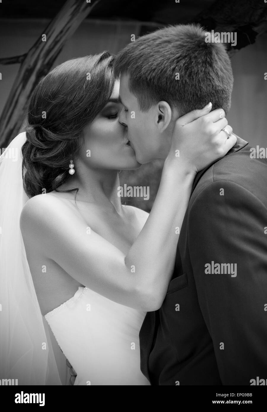 I giovani sposi novelli baciare e giorno di estate (monocromatico) Foto Stock