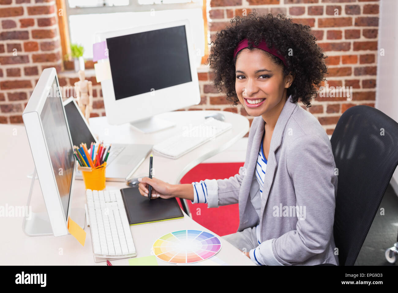 Femmina editor di foto utilizzando il digitalizzatore in office Foto Stock