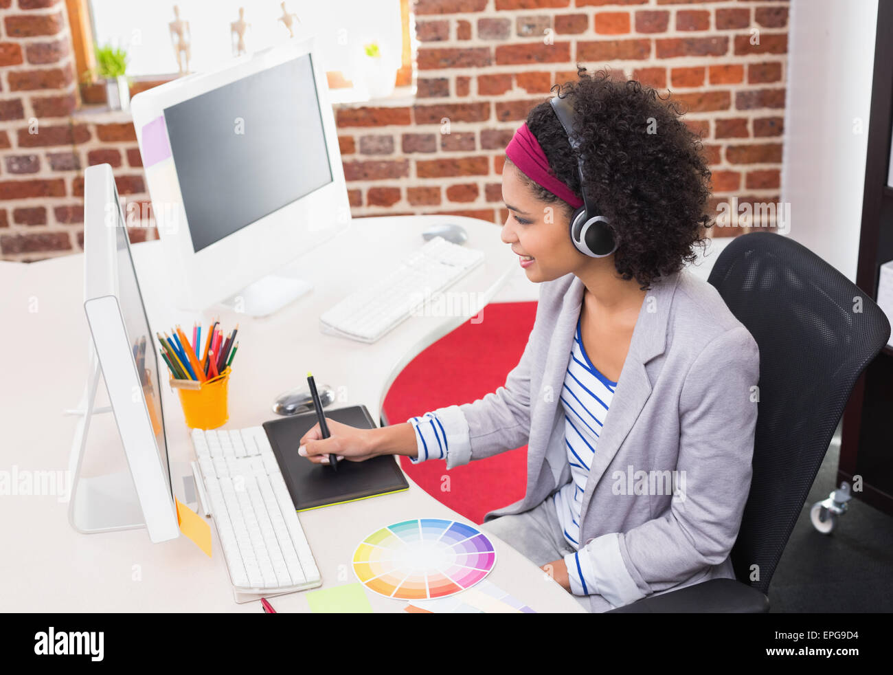 Femmina editor di foto utilizzando il digitalizzatore in office Foto Stock