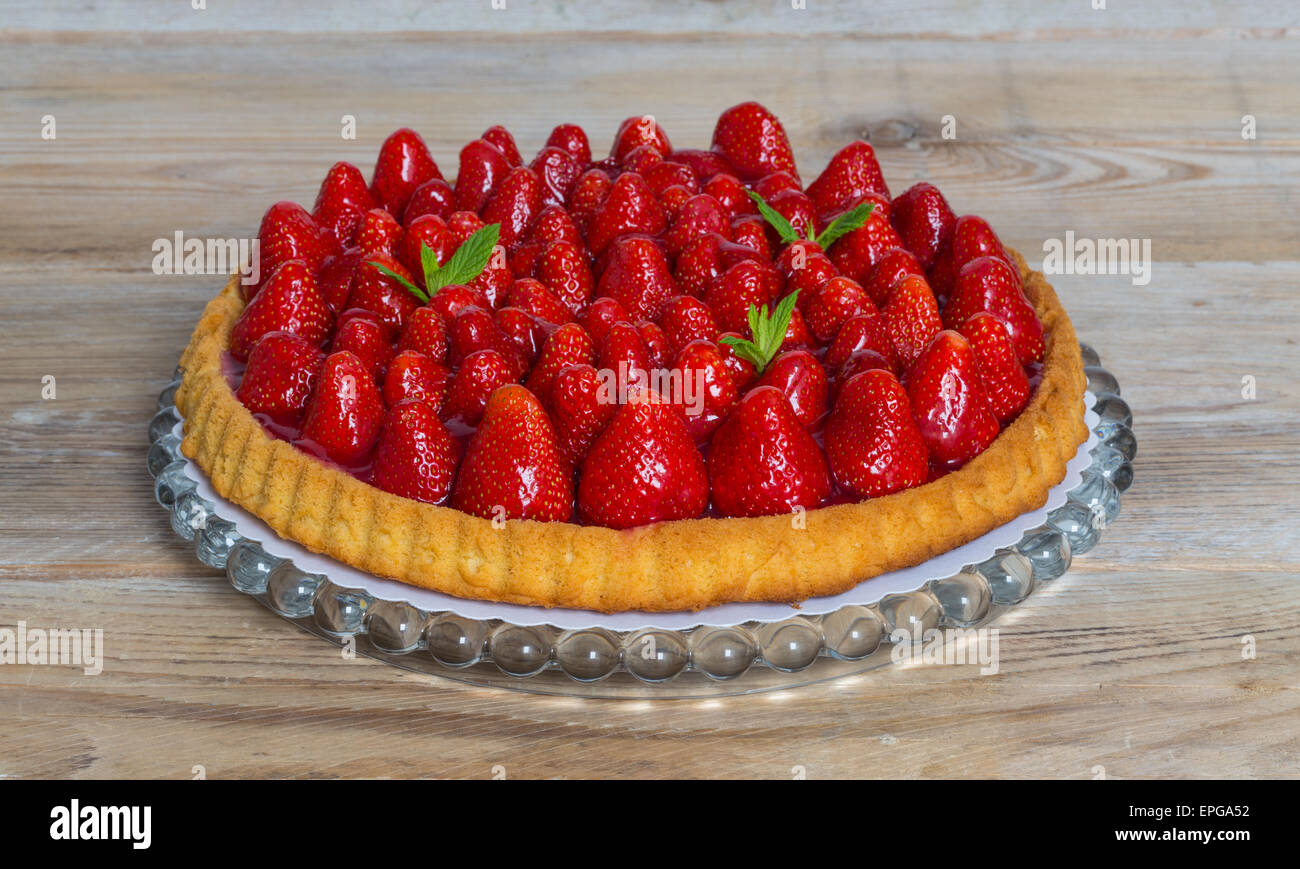La torta di fragole con le foglie di menta su un legno rustico. Foto Stock