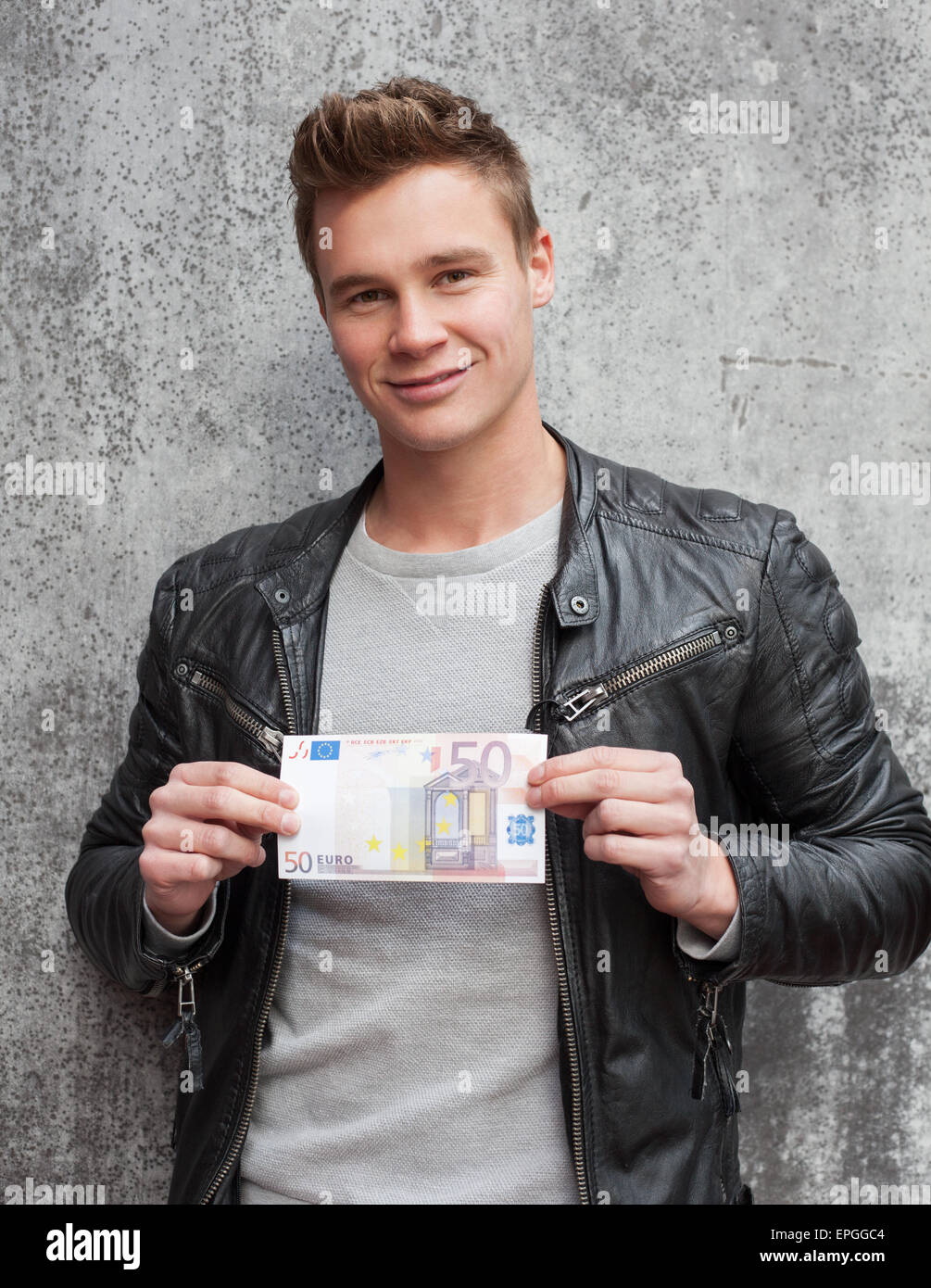 Casual giovane ragazzo holding 50 euro nota Foto Stock