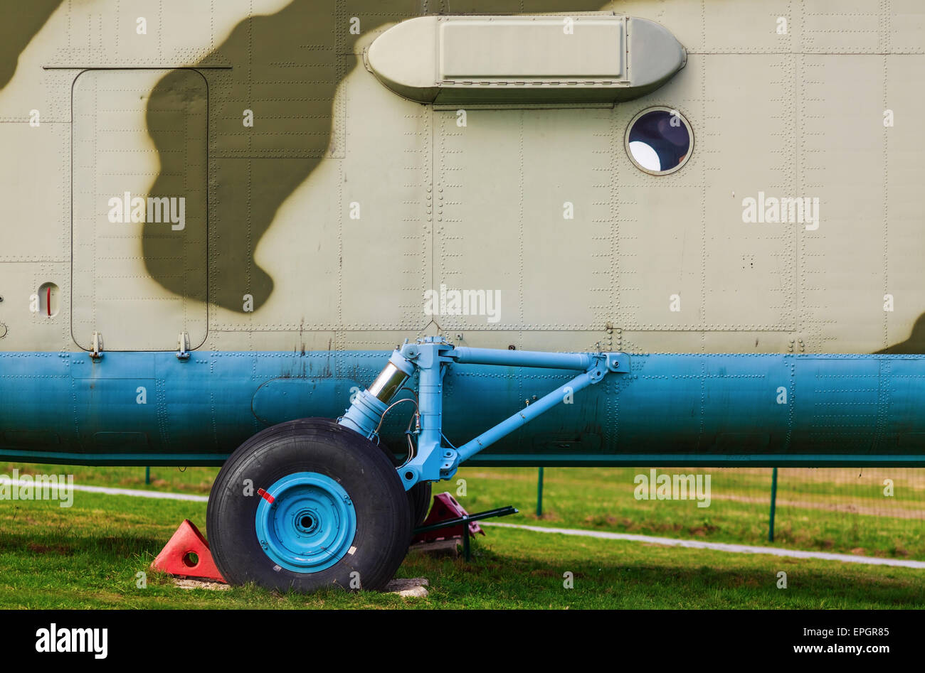 Un frammento del vecchio tipo di autocarro pesante elicottero militare di close-up. Carrello di atterraggio di un elicottero sul prato verde. Foto Stock