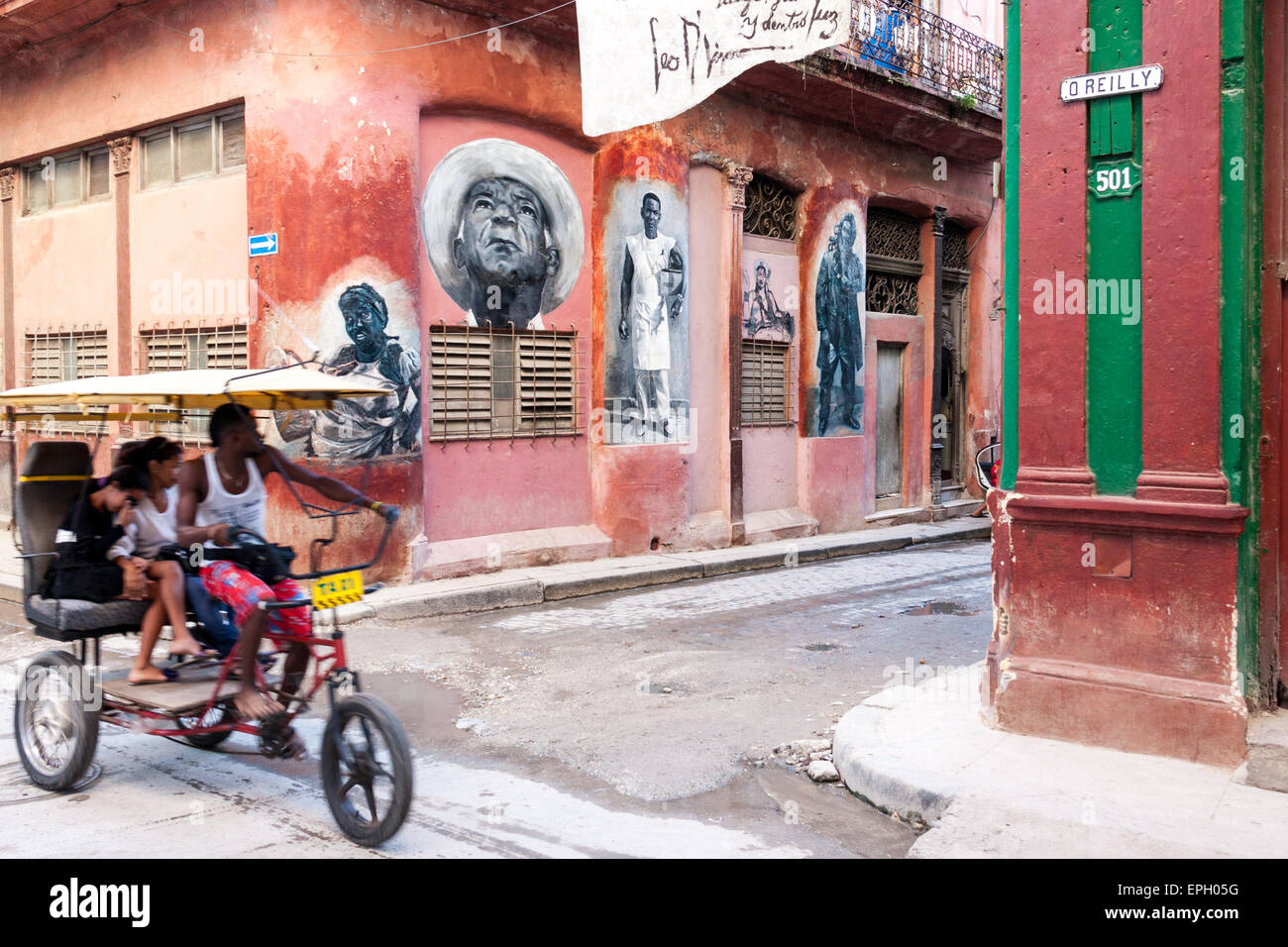 Due persone su un triciclo su O'Reilly street, Havana, Cuba Foto Stock