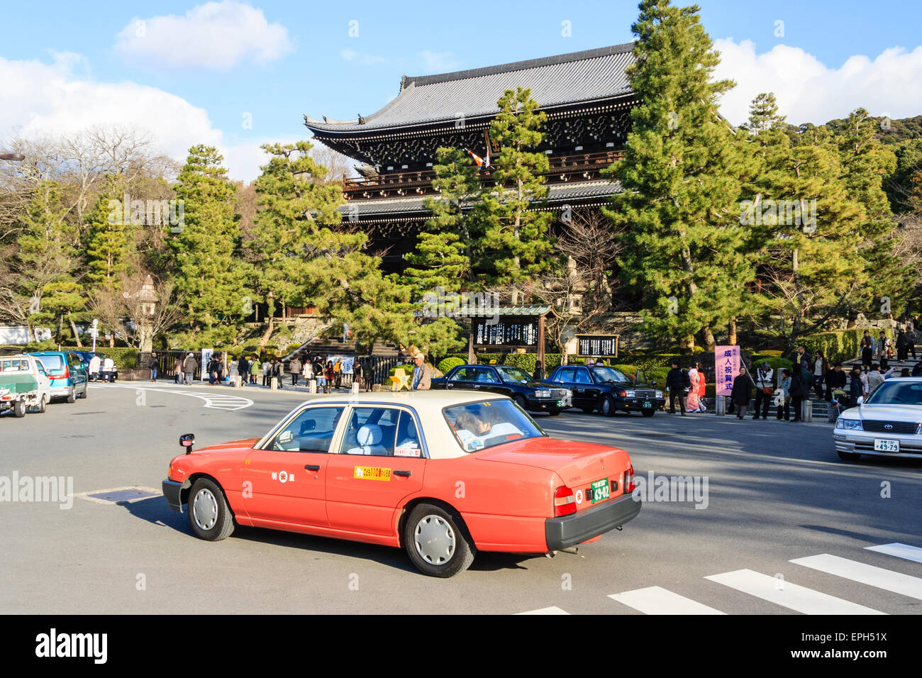 Giappone, Kyoto, Chion-nel tempio. In legno massiccio gatehouse, Sammon, con strada in primo piano e il servizio taxi passando, cieli blu. Foto Stock