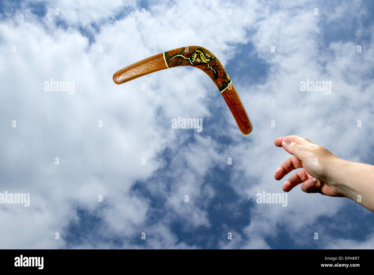 Gettare un dipinto, legno midair boomerang con cielo blu e Sfondo nuvola. Foto Stock