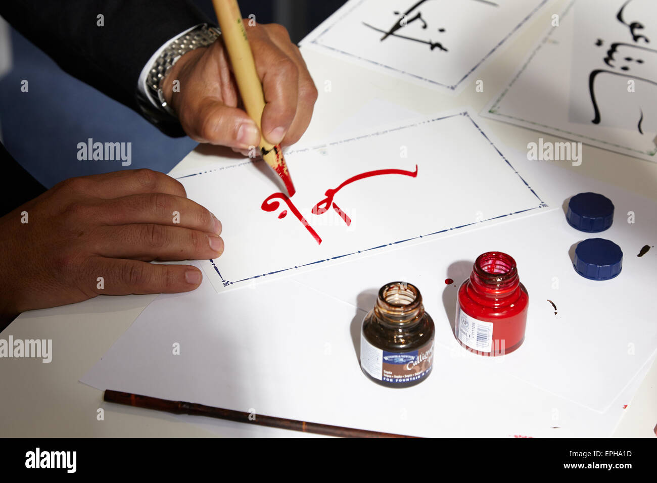 Uomo a scrivere in arabo calligrafia al Salone del Libro, fiera internazionale del libro di Maggio 16, 2015 a Torino, Italia Foto Stock