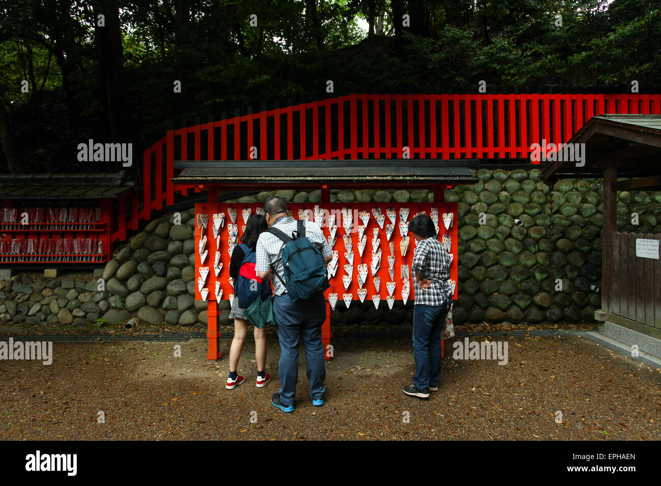 Persone appendere i desideri e fare sacrifici fatti di piccole tavole di legno su un fox ema a Fushimi Inari santuario a Kyoto. Foto Stock