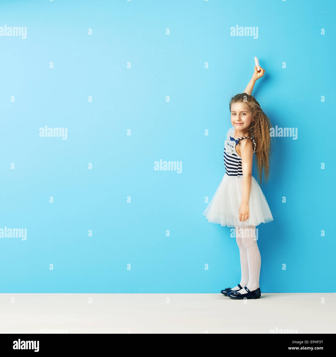 Carino bambino scrivere sul muro con un gesso Foto stock - Alamy