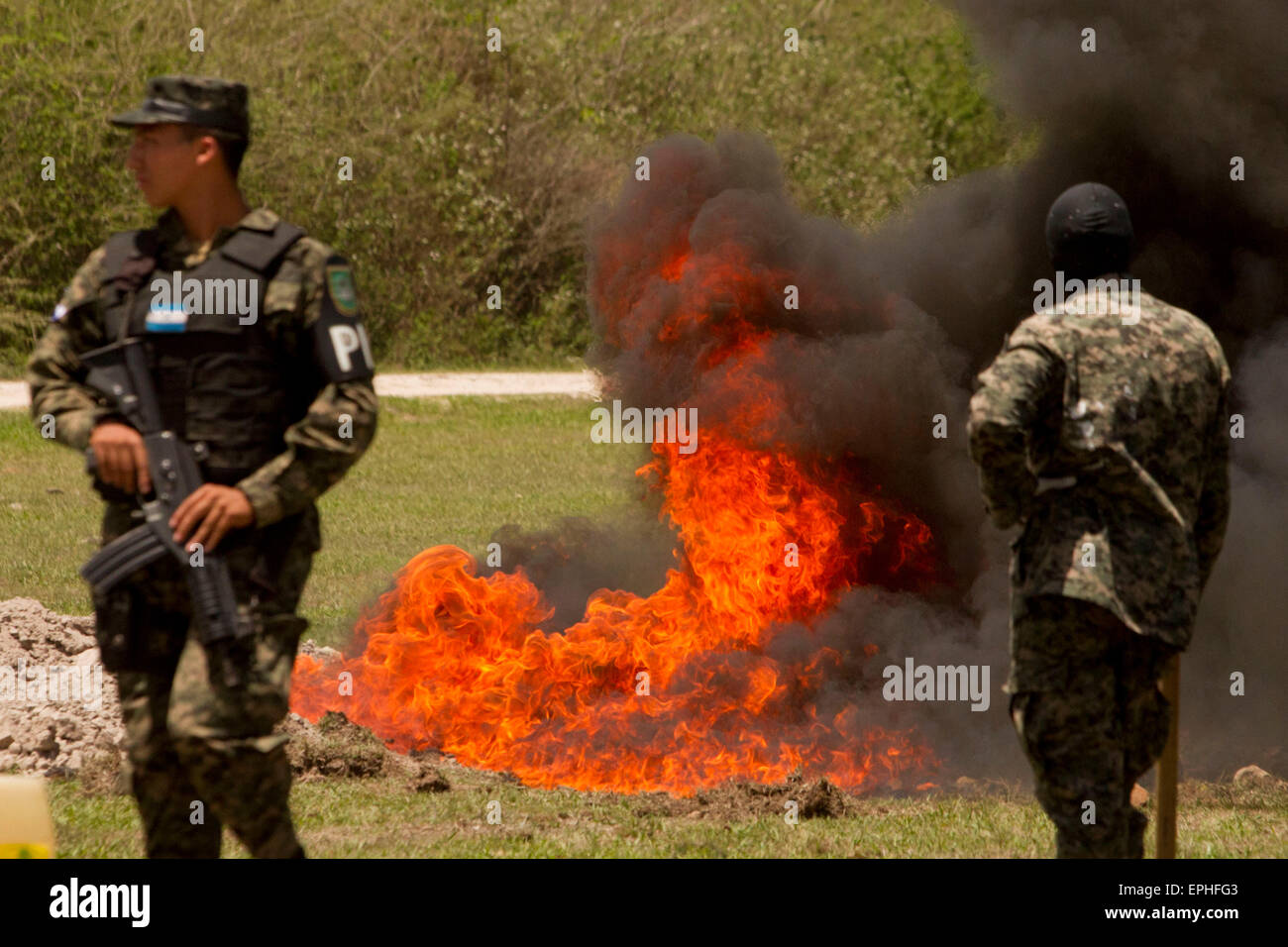 Mateo, Honduras. 18 Maggio, 2015. I membri dell'esercito Hoduran guardia durante la masterizzazione di confezioni di farmaci nel villaggio di Mateo, a sud-ovest di Tegucigalpa, Honduras, il 18 maggio 2015. Un totale di 175kg di cocaina sono stati sequestrati in aprile durante una operazione militare, secondo il National interistituzionale di forza di sicurezza. Credito: Rafael Ochoa/Xinhua/Alamy Live News Foto Stock