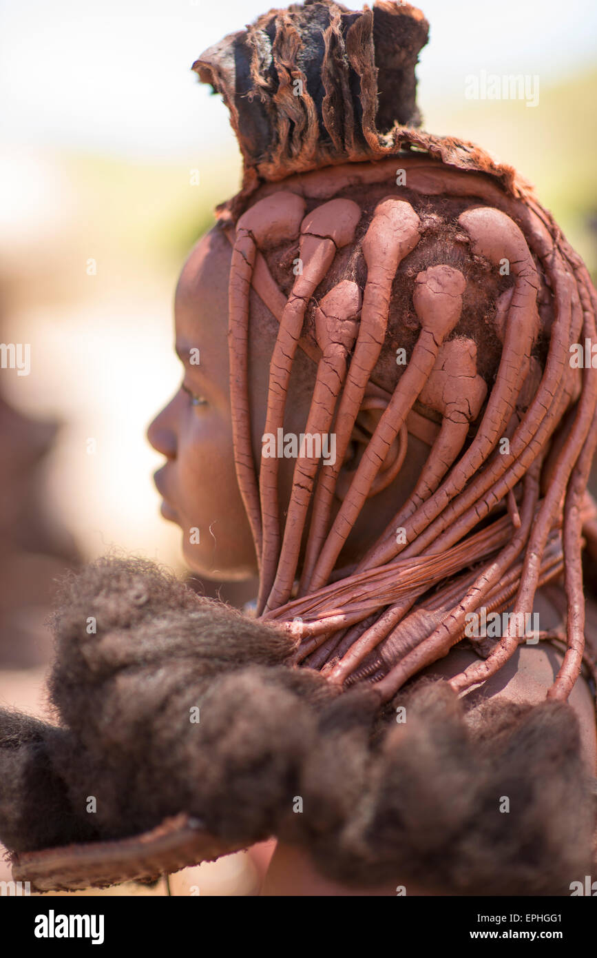 Africa, Namibia. Tribù Himba Village. Chiudere l'immagine delle donne indigene lo stile dei capelli. Foto Stock