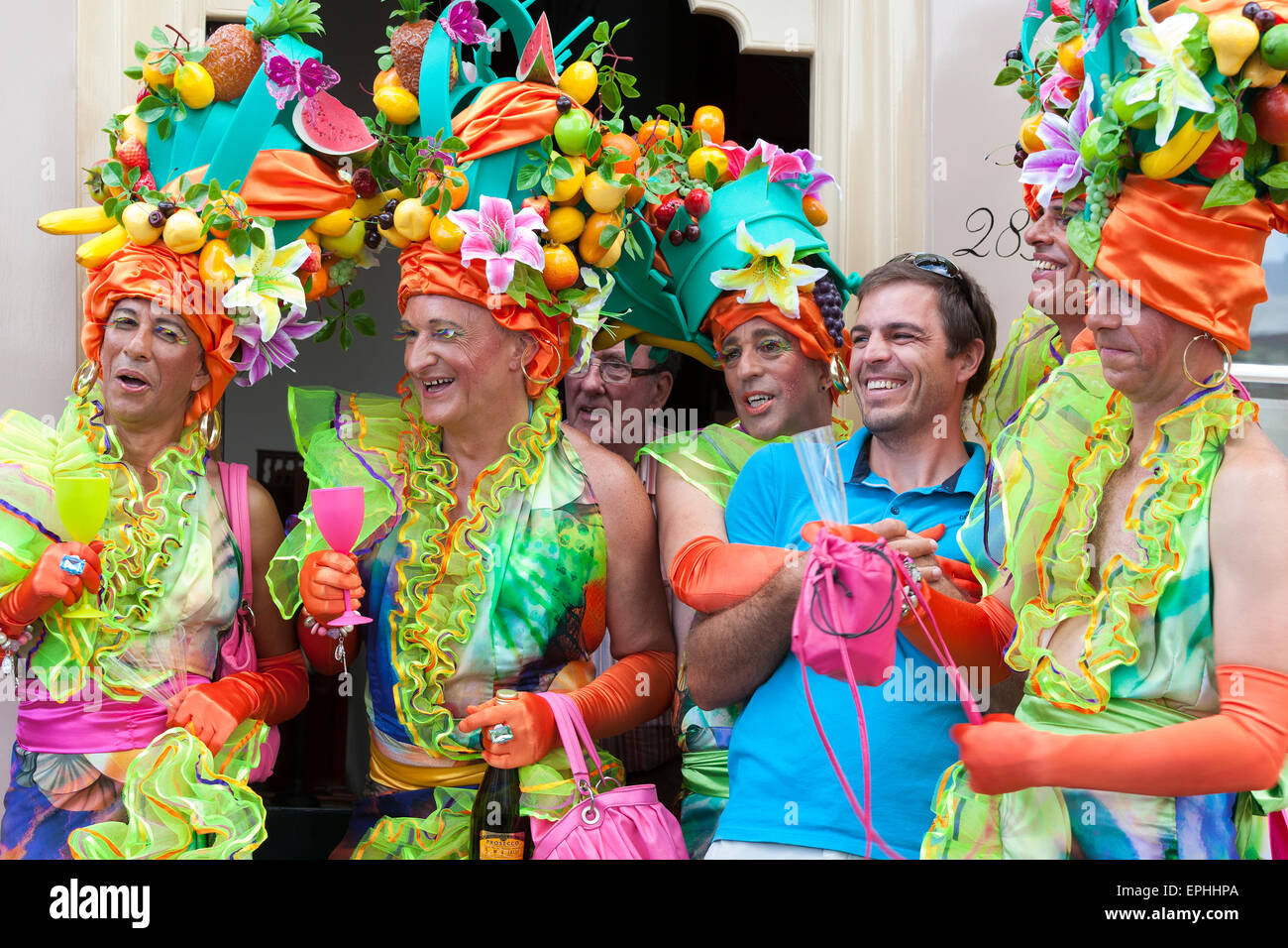 Un visitatore a Amsterdam Gay Pride Canal Parade pone con 5 Carmen Miranda lookalike cross-ravvivatori Foto Stock