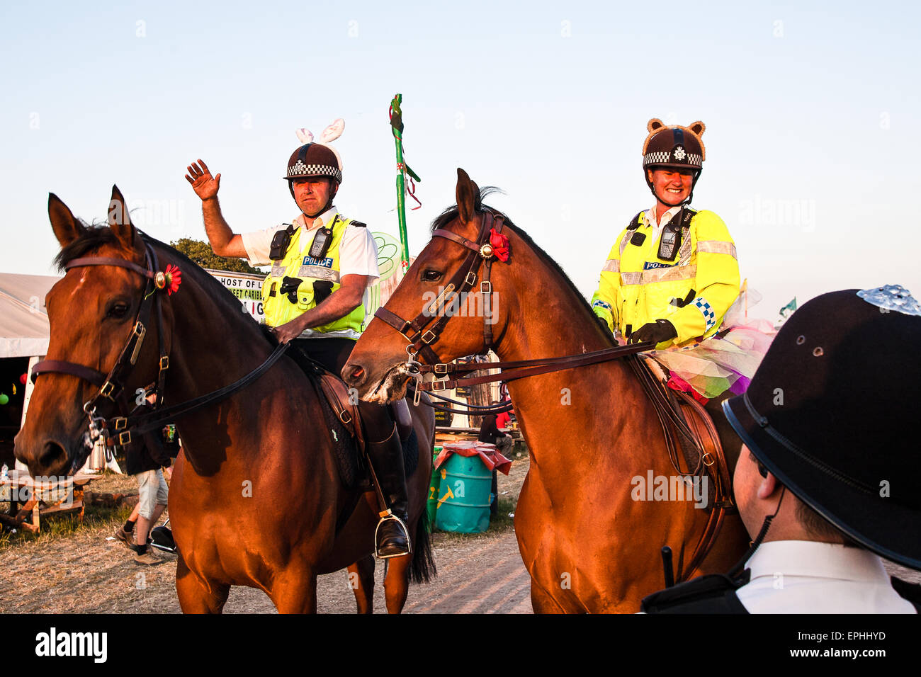 Cavallo polizia montata entrare nella festa di famiglia atmosfera da medicazione fino al Glastonbury festival/ 'Glasto" tenutosi in fattoria Foto Stock