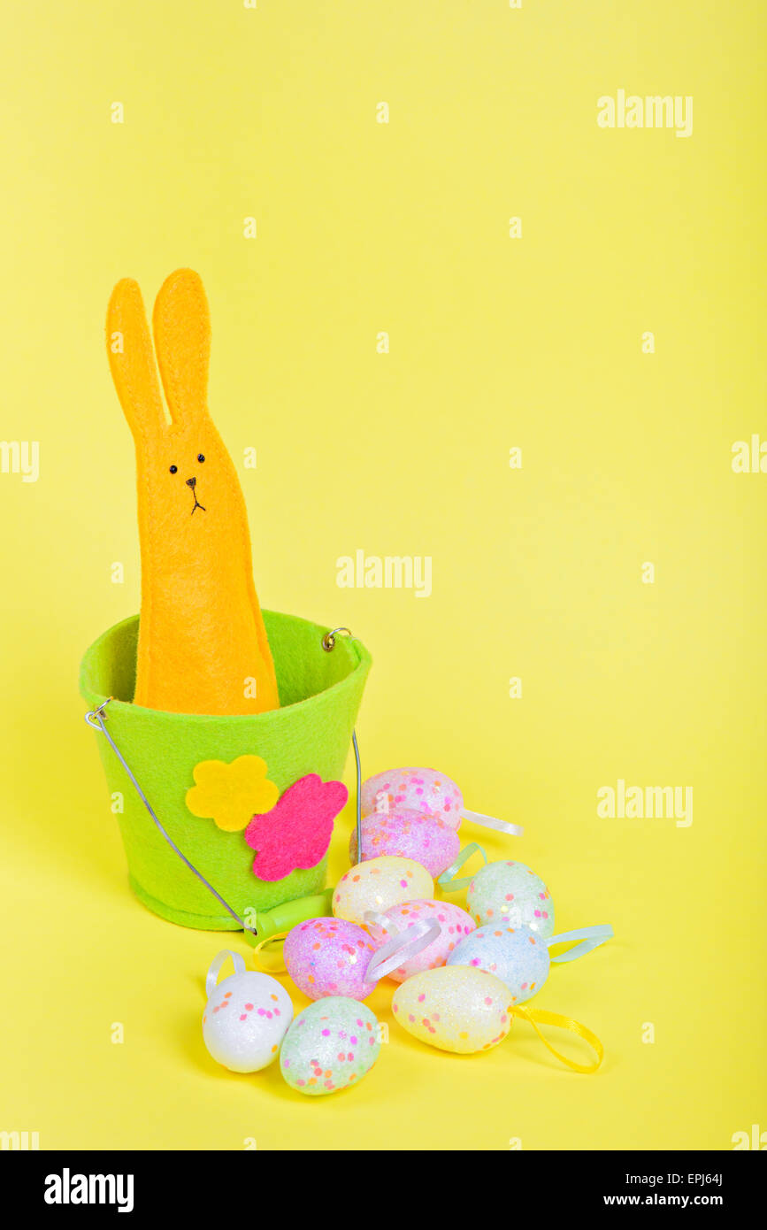 Coniglietto di pasqua nel secchio su giallo Foto Stock