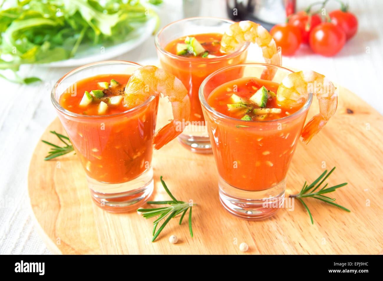 Delizioso freddo gustosa minestra di pomodoro gazpacho con avocado e gamberi nella porzione bicchieri sulla tavola di legno, primo piano, orizzontale Foto Stock