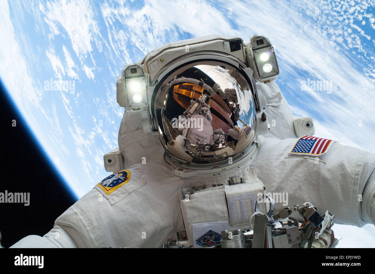 Stazione Spaziale Internazionale Expedition 38 astronauta della NASA Mike Hopkins durante la seconda delle due i viaggi futuri, sparsi in una quattro giorni di tempo per cambiare una pompa dell'acqua difettosa sull'esterno della terra stazione spaziale in orbita il 24 dicembre 2013. Egli era unita su entrambi i viaggi futuri da astronauta della NASA Rick Mastracchio che si vede riflessa nella visiera del casco. Foto Stock