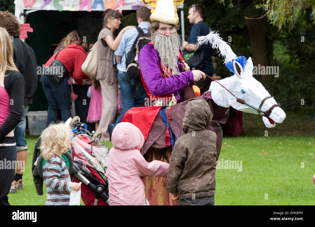 Un tradizionale polacco clown su una finta di cavallo in un parco di Southend Foto Stock