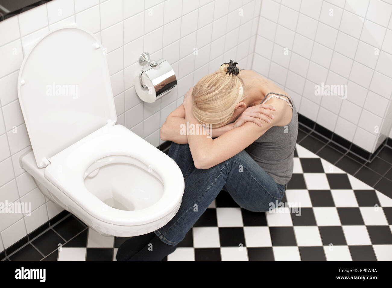 Disperato anoressica giovane donna alla toilette Foto Stock