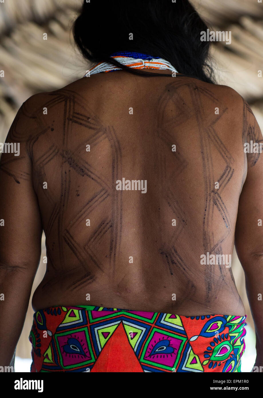 Panama, Provincia di Darien, Puerta Lara, Wounaan tribù donna mostrando il suo tatuaggio Jagua nel suo indietro Foto Stock