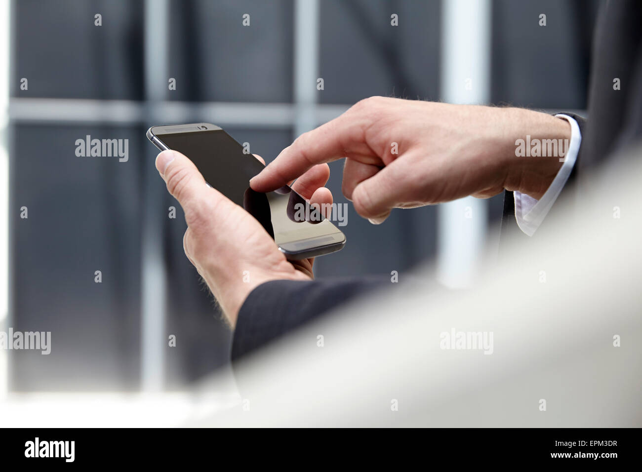 Le mani di imprenditore toccando lo schermo del suo smartphone Foto Stock
