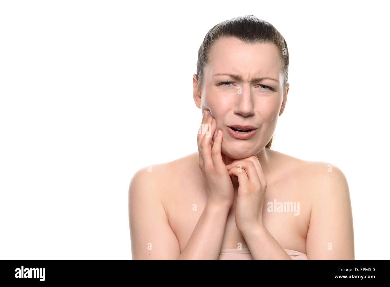 Vicino la giovane donna che indossa il tubo Tops, soffre di un doloroso mal di denti, tenendo il suo viso durante il pianto alla fotocamera. Foto Stock