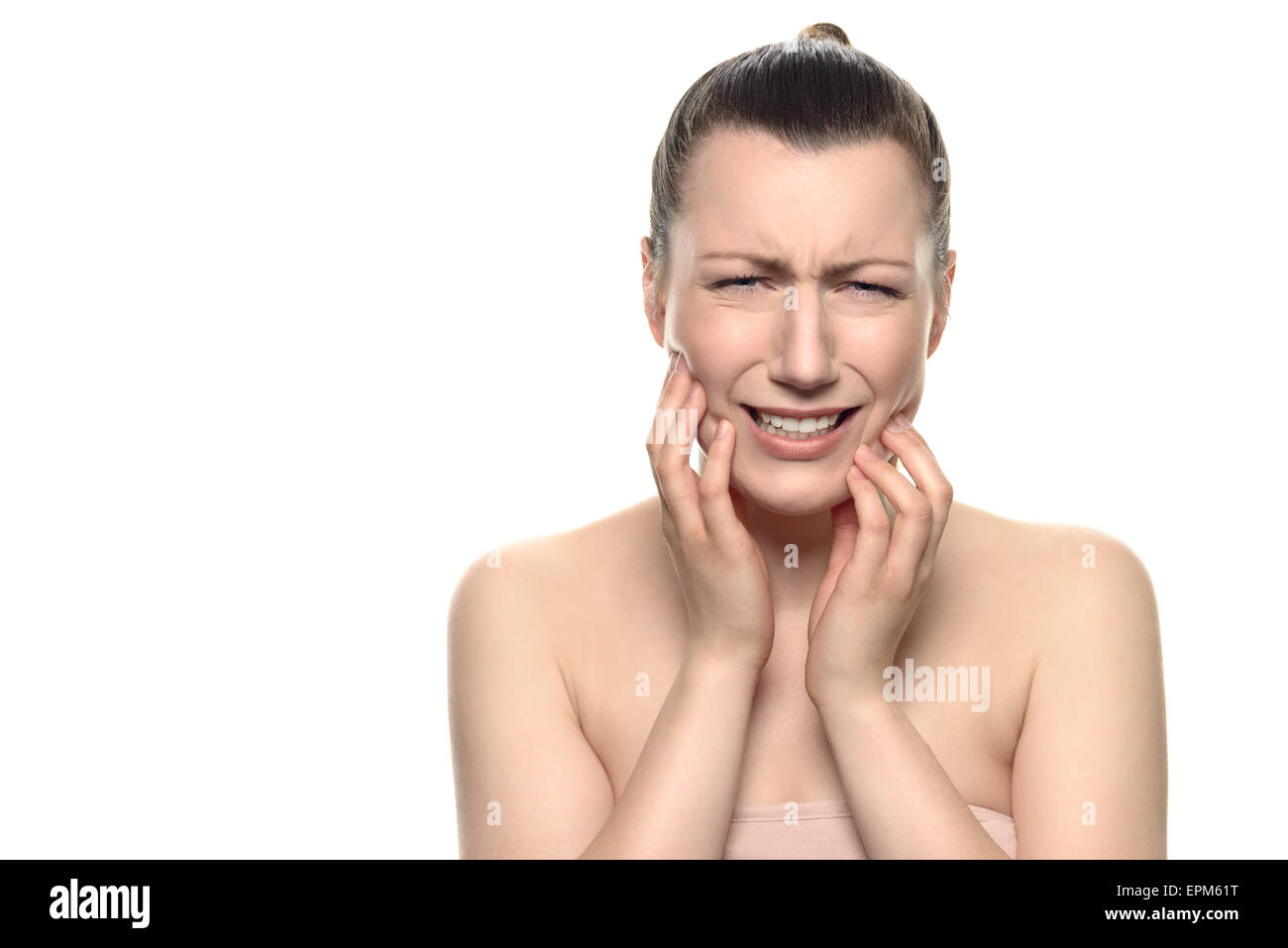 Vicino la giovane donna che indossa il tubo Tops, soffre di un doloroso mal di denti, tenendo il suo viso durante il pianto alla fotocamera. Foto Stock