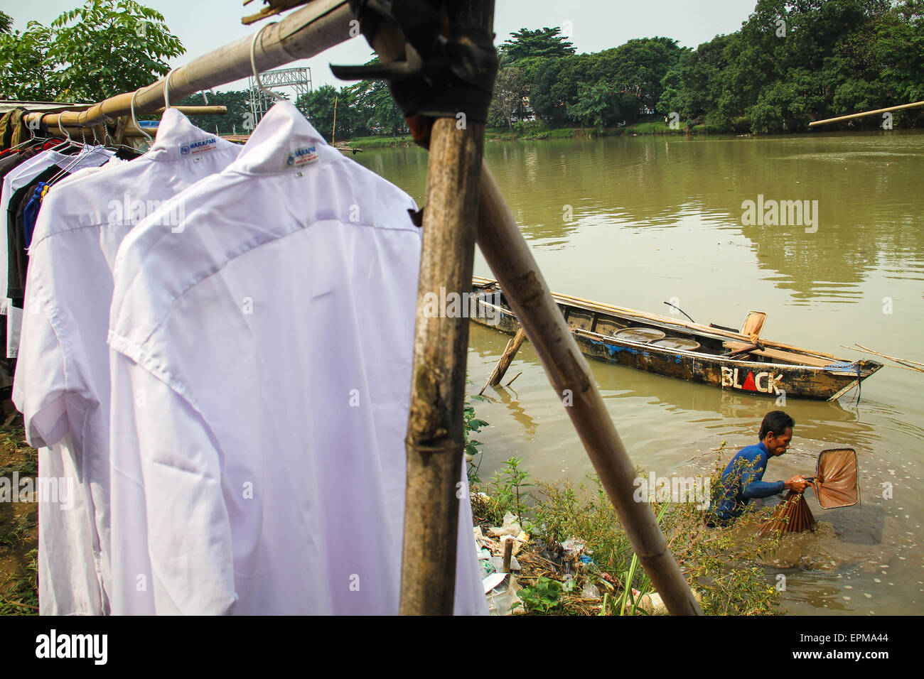 Tangerang, Indonesia. 18 Luglio, 2014. Dodi (38 anni), che lavora come un baco da seta asilo (Tubifex), è alla ricerca di bachi da seta al fiume Cisadane, Tanah Gocap, Tangerang. Dodi giorno può ottenere 25-30 lattine per tin bachi da seta per 5 mila e venduti in negozi di pesce in Tangerang. © Garry Andrew Lotulung/Pacific Press/Alamy Live News Foto Stock