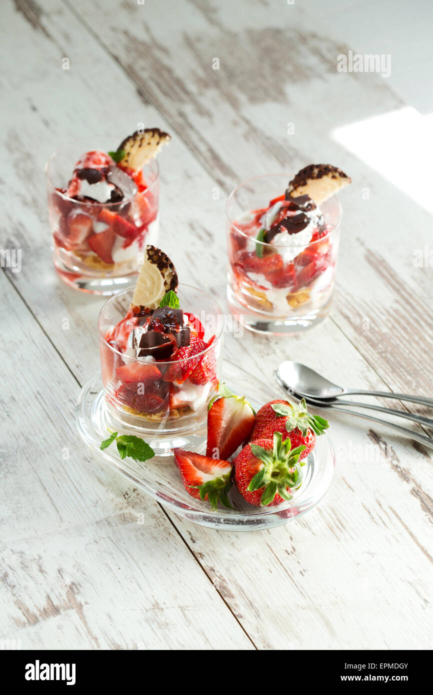 Il dessert in bicchieri con yogurt, ricotta e fragole e cioccolato marshmallow Foto Stock
