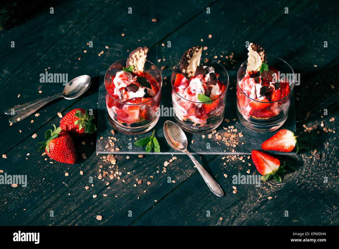 Il dessert in bicchieri con yogurt, ricotta e fragole, scaglie di cioccolato e cioccolato marshmallow Foto Stock