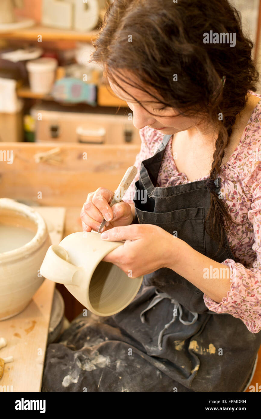 Potter in officina a lavorare sulla brocca di terracotta Foto Stock