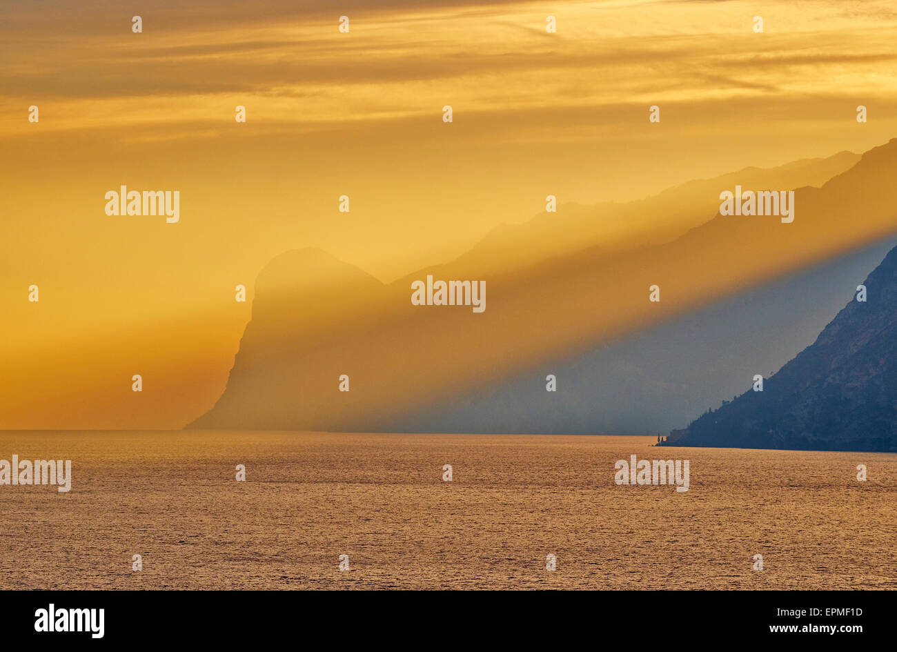 L'Italia, Torbole sul lago di Garda con le montagne al tramonto Foto Stock