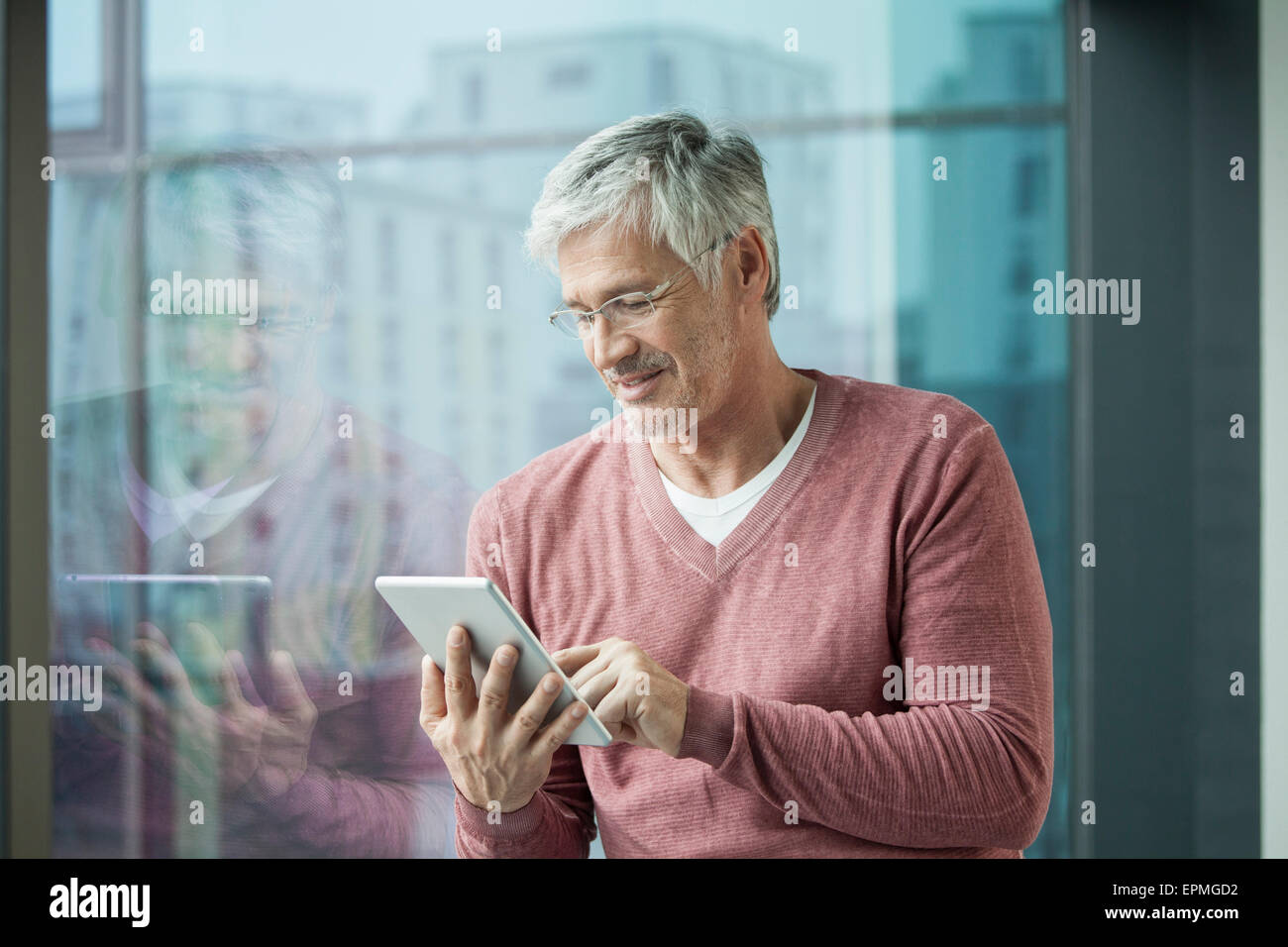 Uomo con tavoletta digitale in casa Foto Stock