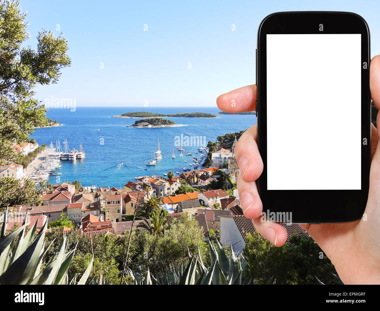 Concetto di viaggio - Fotografia turistica città sull isola di Hvar nel Mare Adriatico, Dalmazia, Croazia sullo smartphone con taglio fuori schermo wit Foto Stock