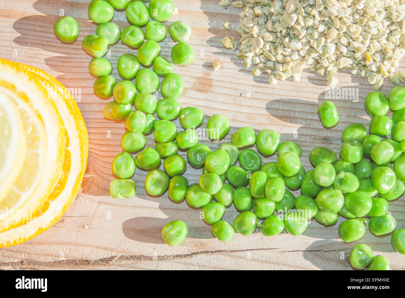 Un mucchio di piselli verdi, tra i piselli secchi e fette di frutta Foto Stock