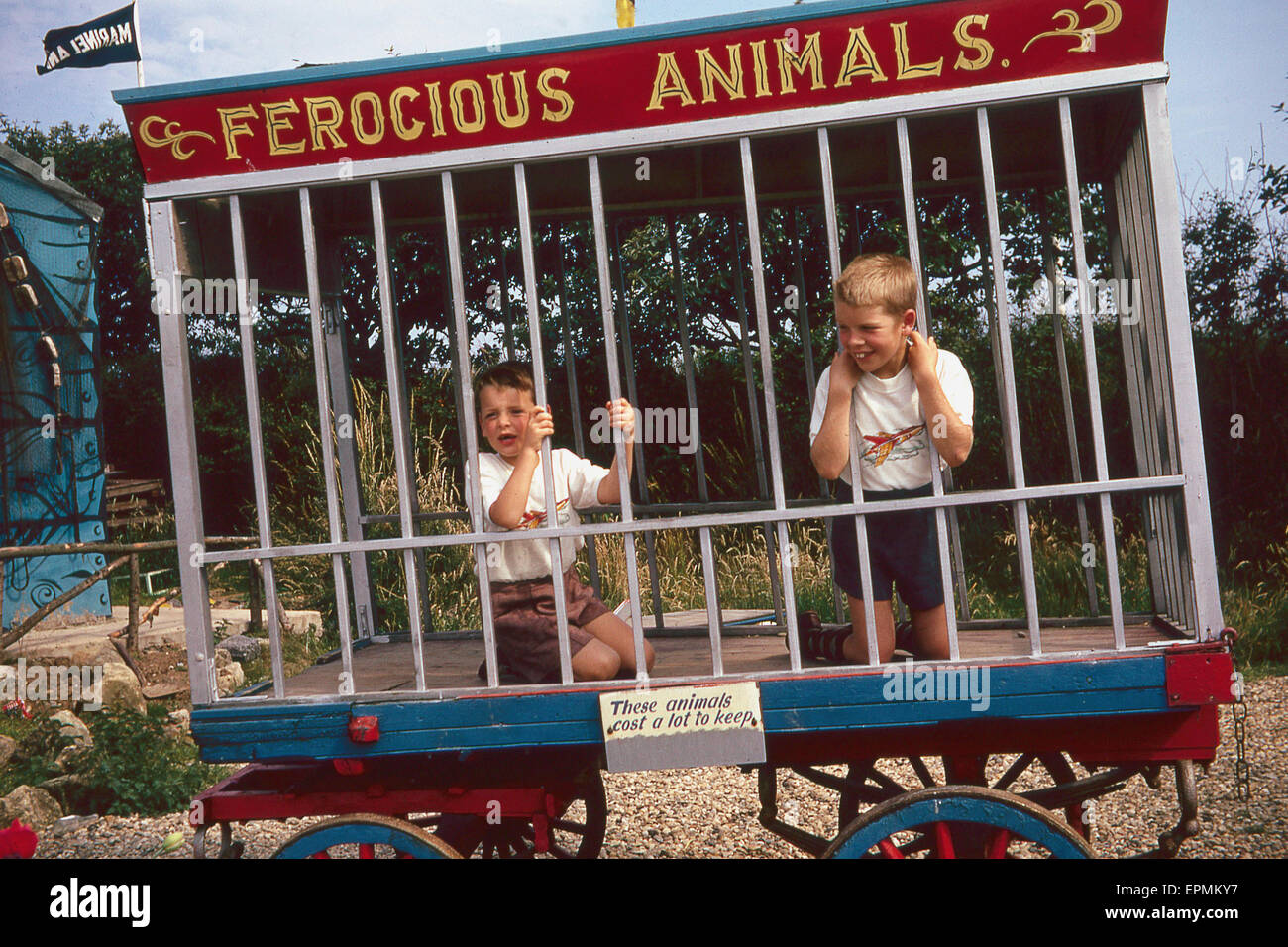 Due piccoli ragazzi divertirsi in una gabbia finta intitolata "animali feroci'. Foto Stock