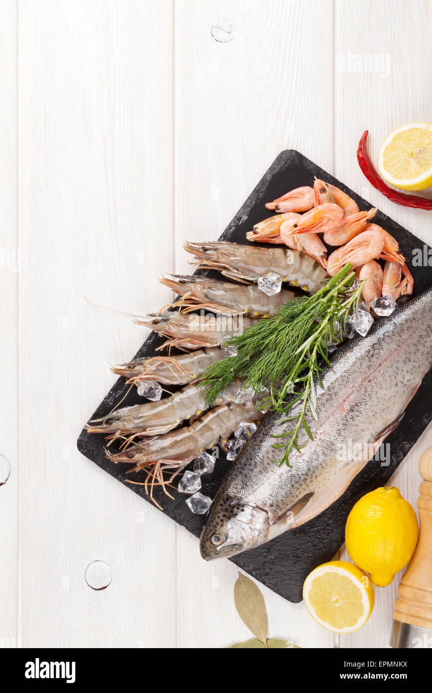 Crudo fresco il cibo del mare con spezie sul tavolo di legno dello sfondo. Vista da sopra con lo spazio di copia Foto Stock