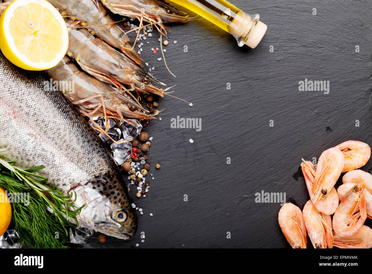Crudo fresco il cibo del mare con spezie sulla pietra nera dello sfondo. Vista da sopra con lo spazio di copia Foto Stock
